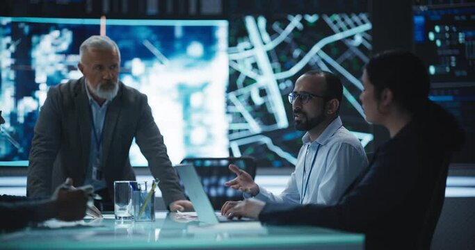 Team of Surveillance Experts Having a Discussion During a Meeting in an Advanced Research Center. Diverse Group of Professionals Monitoring an Active Operation with Satellite Tracking Technology