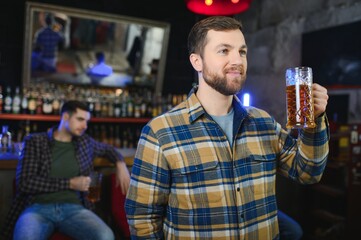 Night in bar. Portrait of cheerful men drinking beer at the bar