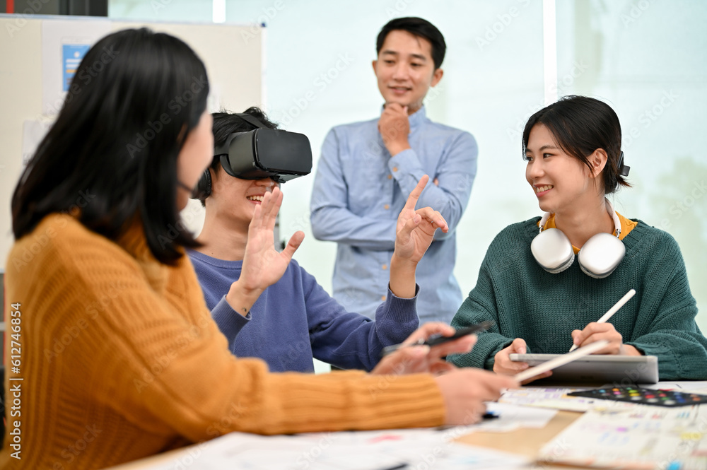 Wall mural An excited Asian male developer tested a new virtual reality headset with his team