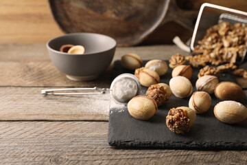 Freshly baked homemade walnut shaped cookies and flour on wooden table, space for text