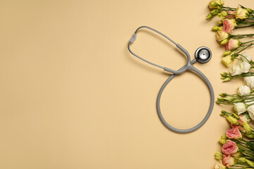Stethoscope and flowers on dark beige background, flat lay with space for text. Happy Doctor's Day