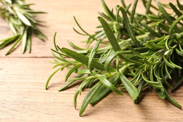 Fresh green rosemary on wooden table, closeup