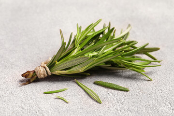 Bunch of fresh rosemary on light textured table, closeup