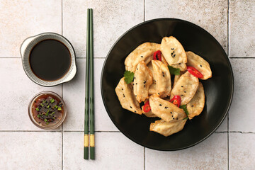 Delicious gyoza (asian dumplings) served on light tiled table, flat lay