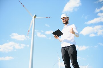 Engineer in field checking on turbine production