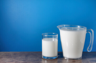 Photo of milk in glass and jug.