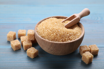 Different types of brown sugar on light blue wooden table