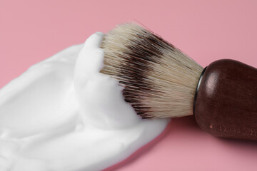 Brush with shaving foam on pink background, closeup