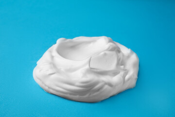 Sample of shaving foam on blue background, closeup
