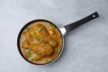 Delicious chicken with curry sauce on grey table, top view