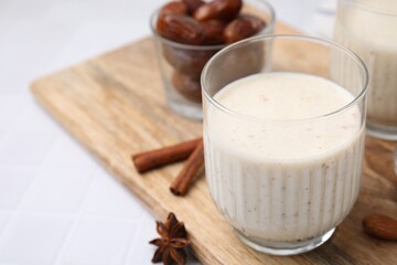 Glass of delicious date smoothie on white table, closeup. Space for text