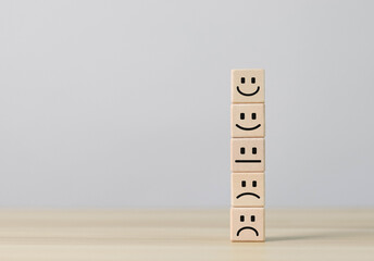 Emotional face symbols on wooden blocks Ratings, services, ratings, customer reviews, satisfaction, evaluations, experiences and quality product marketing recommendations.