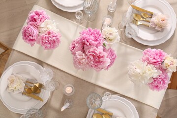 Stylish table setting with beautiful peonies and burning candles, flat lay