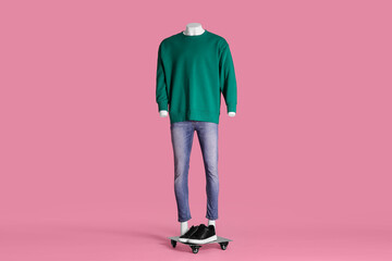Male mannequin with sneakers dressed in green sweatshirt and jeans on pink background. Stylish...