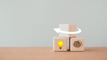 Two wooden cube blocks with   a tangle of thoughts and brighten lightbulb under flip white arrow o , for creative, solution, problem solving, idea, intelligent concept