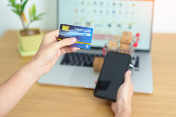 woman hand holding credit card and using laptop with mobile phone for online shopping while making order. Marketplace platform website, technology, ecommerce, shipping delivery and online payment