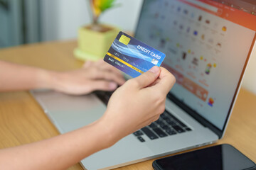 woman hand holding credit card and using laptop with mobile phone for online shopping while making order. Marketplace platform website, technology, ecommerce, digital banking and online payment