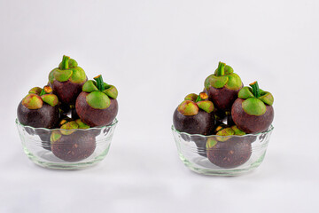 Mangosteen in a glass cup on white background.