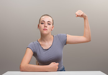Strong woman flexes muscle, defiant