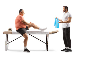 Obraz na płótnie Canvas Physical therapist showing exercise to a mature man with an injured knee