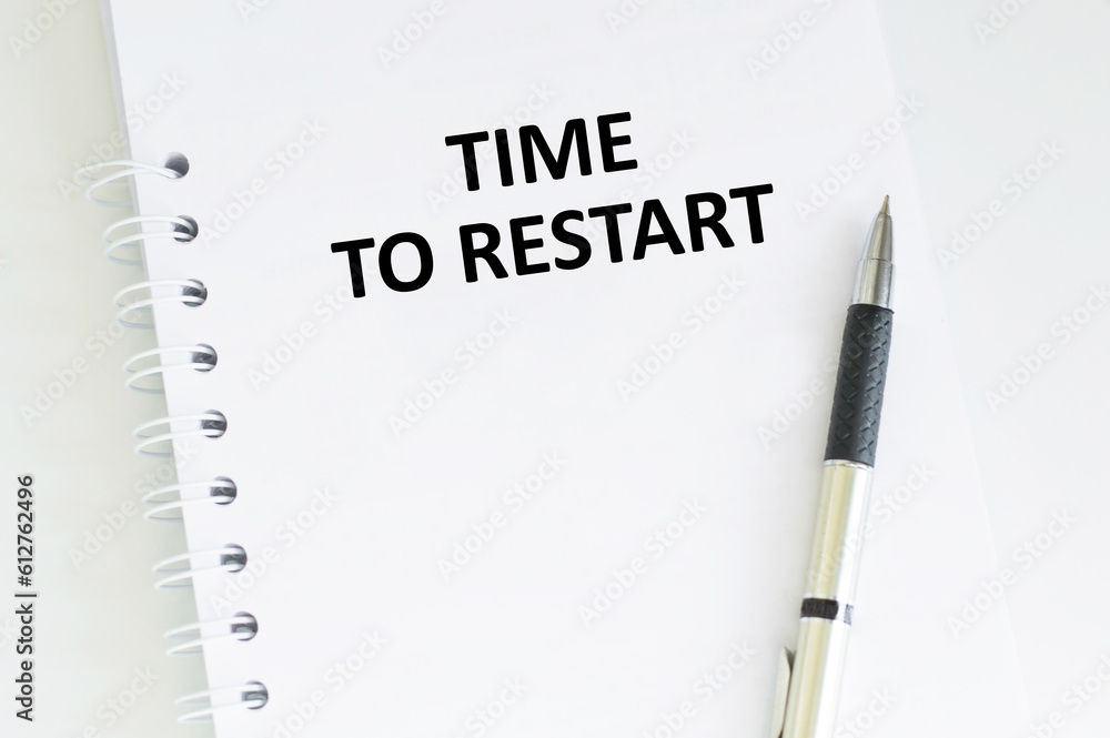 Poster time to restart text written on a notebook on the wooden background