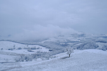 Fototapeta na wymiar Blizzard in the mountains. Snowy hills, mountains, nature, horizon. Natural background. Appennino Tosco-emiliano