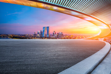 Asphalt road and city skyline with modern building at sunset in Suzhou, Jiangsu Province, China.