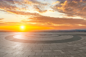 Circular city square and city skyline with sky clouds at sunset