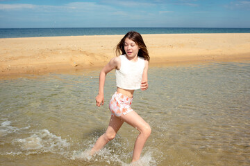 Pretty little girl playing by the ocean