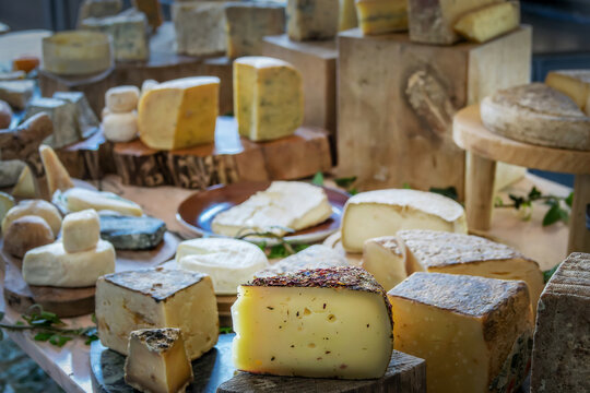Large choice of French ripened cheese on a wooden rustic board