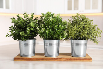 Artificial potted herbs on white marble table in kitchen. Home decor