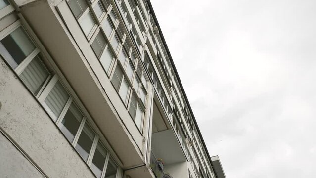 The facade of an unusual long apartment building with unusual balconies. Dolly camera7. A long house with a strange design