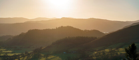 Sunrise over a ridge in the Derwent Fells from below the summit of Grisedale Pike in winter in the English Lake District, UK.