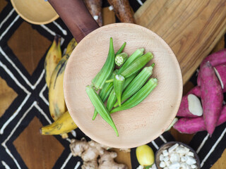 african woman chopping okra fruit overhead