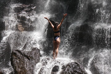 junge, Frau possiert am Kanto Lampo Wasserfall auf Bali - obrazy, fototapety, plakaty