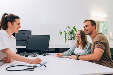 gynecologist and young couple in the doctor's office for a pregnancy check