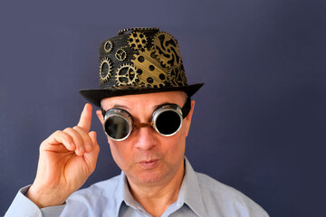 adult elderly man, eccentric scientist or inventor in hat and black glasses in steampunk style,...