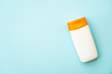 Sun screen products on blue background with palm leaves. Sun protection for summer holidays, beach relax and sunbathing. Flat lay with space for text.