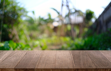 image of wooden table in front of abstract blurred background of outdoor garden lights. can be used for display or montage your products.Mock up for display of product.