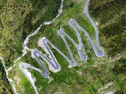 Curves of the scenic alpine Spluegen Pass in Switzerland. Aerial view