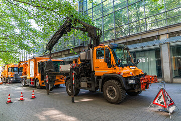 Large orange rescue vehicles standing in the pedestrian zone of the city.