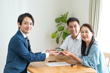 住宅の模型を持つ日本人夫婦