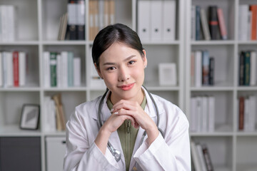 Portrait of beautiful smiling female Asian doctor in medical office. Health care concept, medical insurance, copy space.