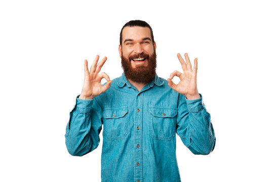 Handsome bearded man is saying it is alright and holding two ok gestures.