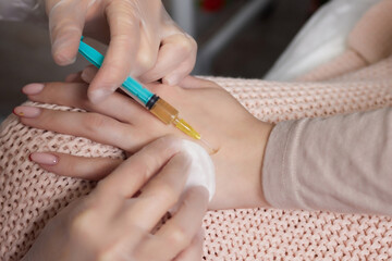 Doctor doing stem cell therapy on a patient's elbow after the injury. Treating knee pain with...