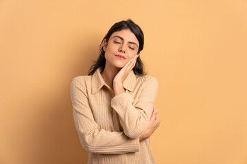 confident brazilian woman embracing self, hugging in studio shot. self love, care concept.