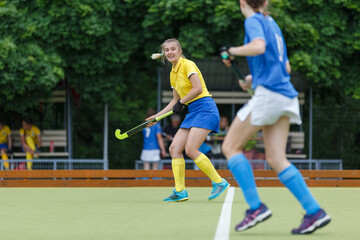 Obraz premium Young woman on the pitch playing field hockey game.
