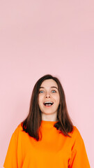 Fototapeta premium Energetic Expression: Impressed and Cheerful Woman with Open Mouth - Vibrant Emotion and Enthusiasm Captured on Pink Background