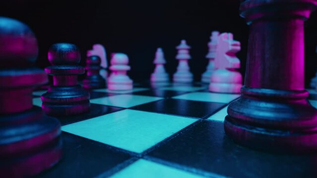 Colorful neon chess pieces on chessboard before battle. Mind games, strategy