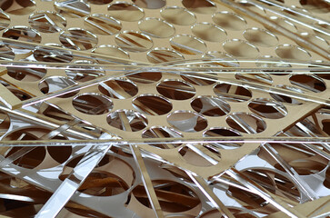 a pile of clear acrylic plastic waste left over from production in an industry. perforated pieces by laser machine